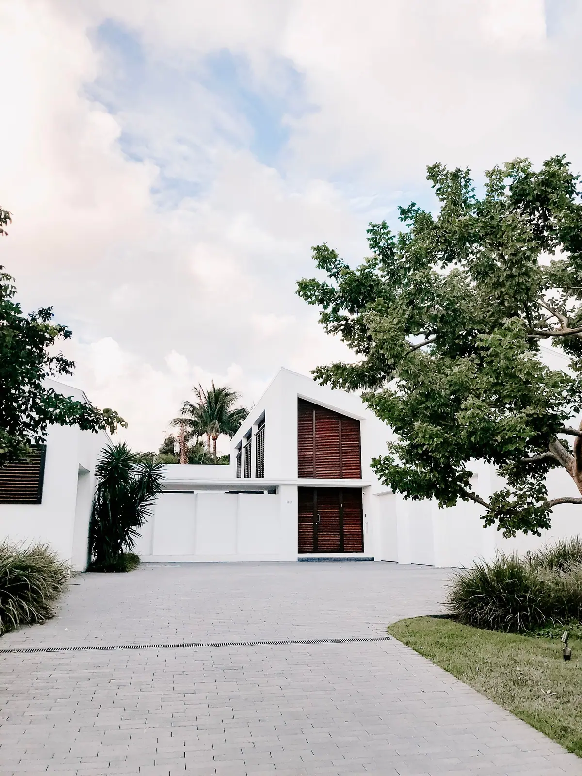 Vivienda moderna de fachada blanca rodeada de vegetación